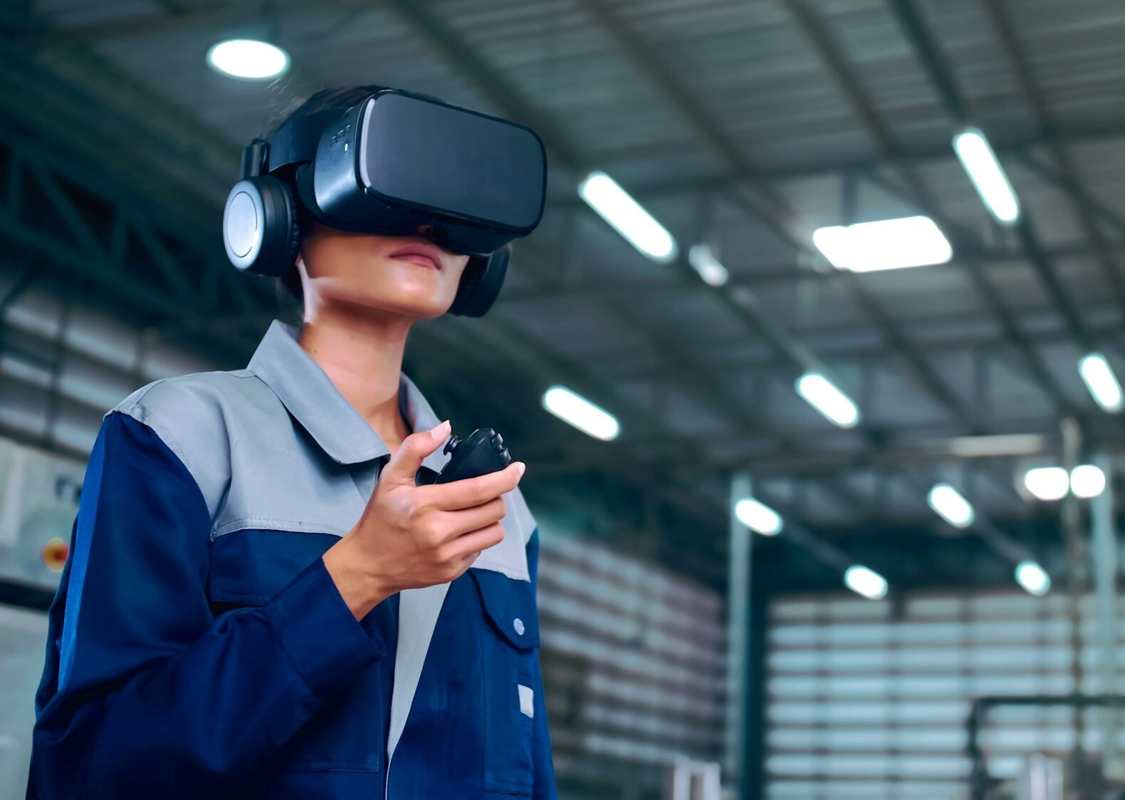 Engineer is using virtual reality glasses to inspect the factory's mechanical control system.